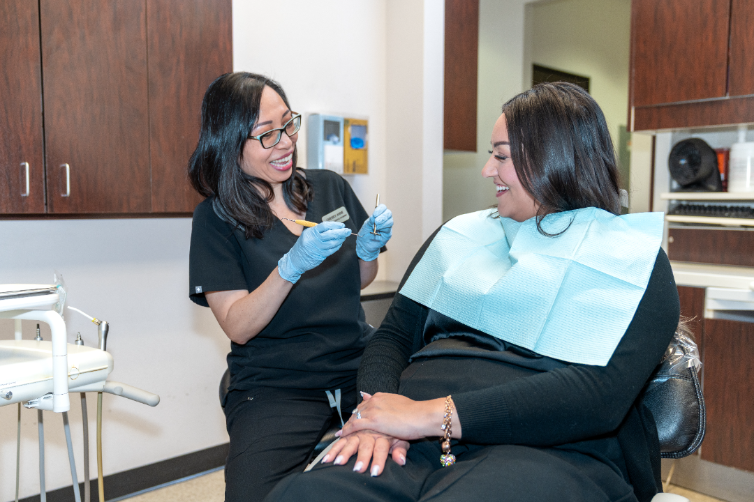 Hygienist sharing a lighthearted moment with a patient during a cleaning